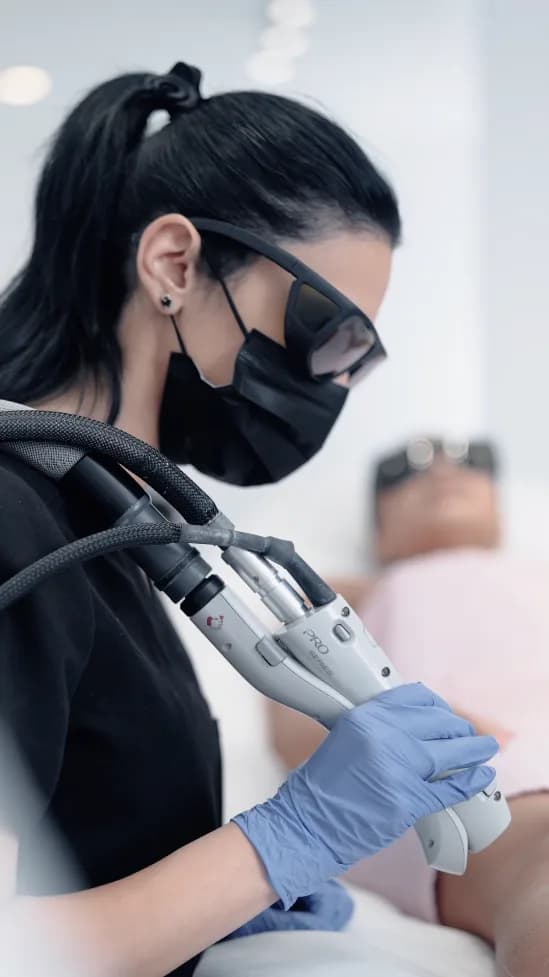 Technician performing laser hair removal on a patient.